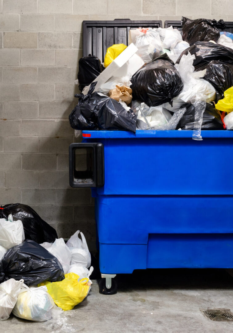 Waste management company has missed pickup due to snowstorm. People keep pilling up trash. Indoors. Vancouver, Canada.
